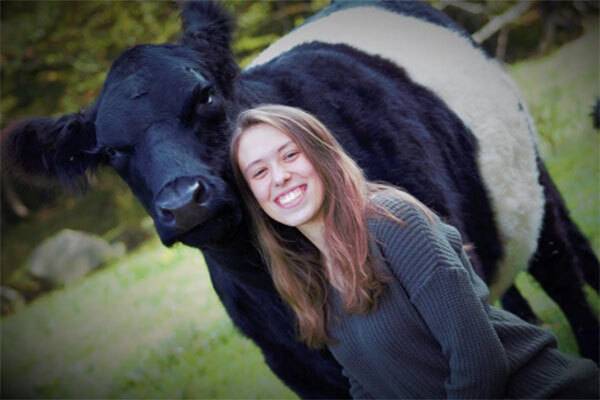 Young woman standing with her cow